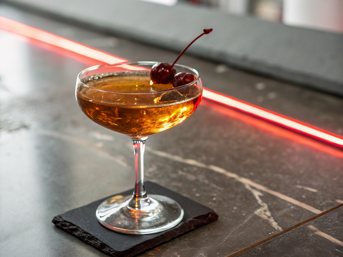 Smoked cocktail in crystal glassware beside natural red wine